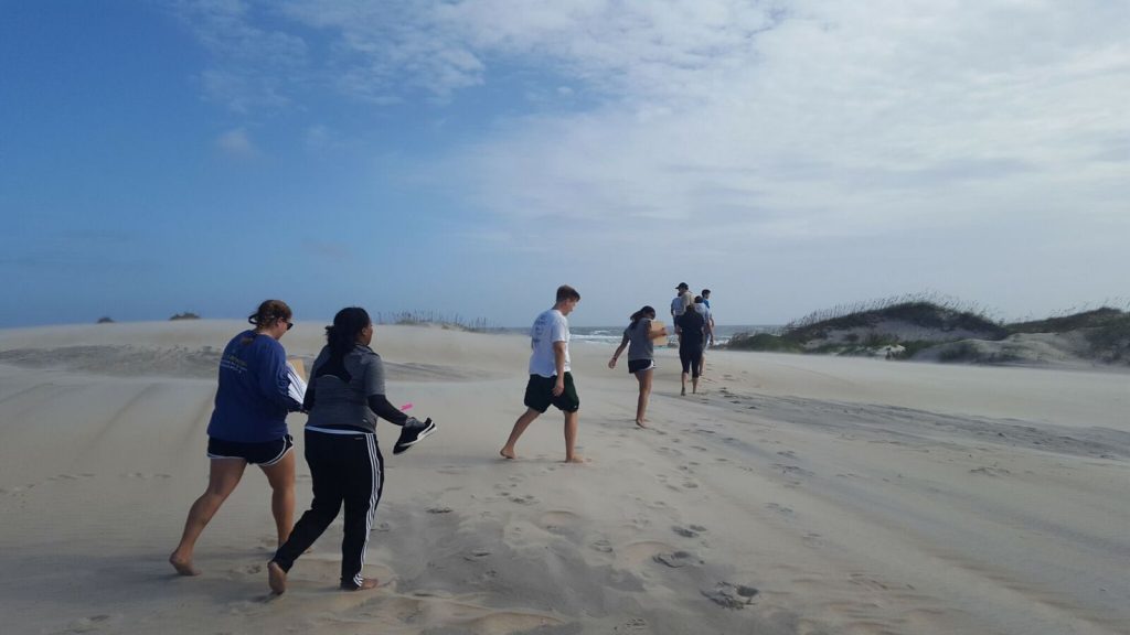 Photo of E3P students walking across the sand at the Outer Banks Field Site.
